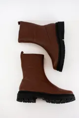 Borcegos de cuero negro con caña media, cierre lateral interno y suela track de goma con plataforma de 4,5 cm.