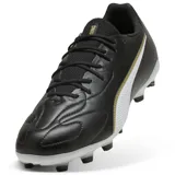 Championes de fútbol Puma King Match FG/AG, color negro con franja Puma blanca y ribete dorado. Suela con tapones moldeados para césped natural seco y césped artificial.
