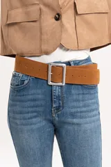 Cinturón ancho de gamuza color camel con hebilla cuadrada metálica plateada.