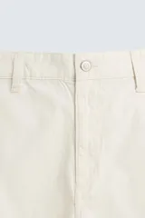 Bermuda de algodón color beige claro con rayas verticales finas en tono más oscuro. Diseño de corte regular con bolsillos delanteros y bolsillos traseros de plastrón.