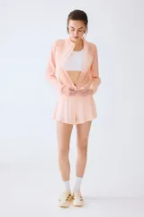 Campera de correr liviana color salmón, de corte estándar con cuello elevado, cierre frontal y tecnología DryMove para absorber el sudor.