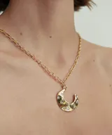 Collar tipo choker con cordón negro y dije de luna creciente con detalles de pequeñas piedras incrustadas.