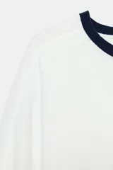 Camiseta de algodón color blanco con cuello redondo, mangas cortas y bajo abullonado, con detalles en color azul marino en el cuello, los puños y el ruedo.