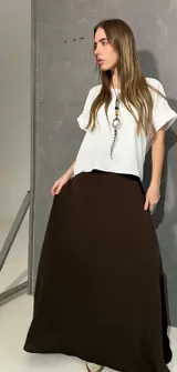 Falda larga marrón, de corte evasé, confeccionada en viscosa y elastano con pretina frontal y elástico trasero.