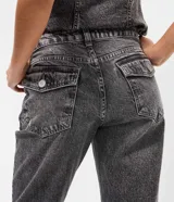 Pantalón de jean con corte flare, tiro medio y efecto desgastado. Presenta cierre frontal con botón, pasantes para cinturón y bolsillos traseros con solapa.