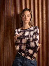 Blusa de terciopelo con estampado a cuadros, corte asimétrico y mangas largas acampanadas.