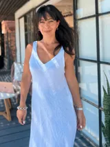 Vestido largo color rosa pálido de lino con breteles finos y escote en V. Tiene corte recto y ruedo con terminación desflecada.