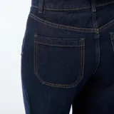 Pantalón de jean azul oscuro con corte wide leg, cintura alta y cierre frontal con botones a la vista. Presenta bolsillos frontales tipo parche.