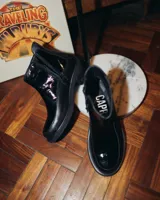 Botas cortas negras de cuero vacuno con elástico lateral y cierre.