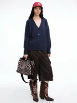 Cardigan de punto color marrón con textura jaspeada, escote en V, cierre frontal con botones y diseño de hombros caídos.