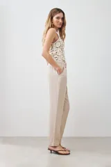 Pantalón de pijama de lino color beige melange, con cintura elástica ajustable con cordón y pespuntes en contraste.