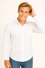 Camisa de algodón de corte clásico, color blanco, con cuello camisero, cierre frontal de botones y mangas largas con puños abotonados.