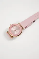 Reloj analógico con caja circular de metal en tono oro rosa y malla de silicona blanca. La esfera presenta un diseño minimalista con marcadores de hora tipo cristal.