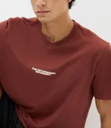 Remera de algodón color bordó, con cuello redondo, manga corta y corte comfort. Presenta un estampado localizado en el pecho con el texto 'The Pathfinders Movement'.