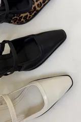 Zapato de cuero color crema con punta fina, pulsera con hebilla y tacón bloque.
