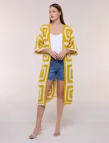 Cardigan largo confeccionado en tejido de punto calado estilo crochet, de color amarillo y blanco, con diseño geométrico de cuadrados, mangas amplias tipo kimono y corte abierto al frente.