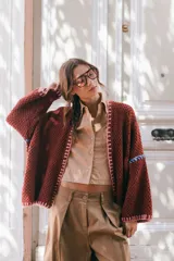 Saco oversize de punto color bordó, con mangas caídas y detalles de bordado artesanal multicolor en los bordes y costuras. Diseño holgado y versátil.