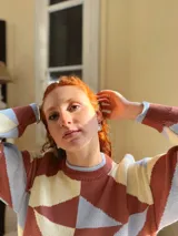 Sweater de punto con diseño geométrico en tonos celeste, marrón y beige.