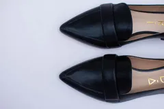 Mocasines negros de cuero con punta fina y detalle de antifaz.