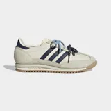 Championes Adidas SL 72 OG de color beige, con las icónicas tres tiras y detalles en azul marino. Cuentan con suela de caucho texturizada y doble cordón en tonos celeste y azul con puntos blancos.