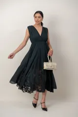 Vestido midi de corte griego color verde oscuro, con escote en V cruzado, sin mangas y amplia falda con detalles en encaje.