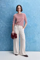 Pantalón sastrero de tiro alto y pierna amplia, color beige, confeccionado en mezcla de viscosa y lino. Presenta cintura con pasadores, cierre frontal con botón, bolsillos laterales y costuras frontales marcadas.