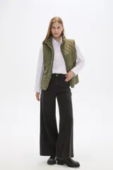 Chaleco acolchado de diseño capitoneado en color verde militar, con cuello alto, cierre frontal con botones a presión y bolsillos laterales con solapa y detalles en contraste.