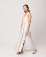 Vestido largo de lino color blanco, gris y amarillo, con breteles anchos, escote recto, elástico en la espalda y tajos laterales.