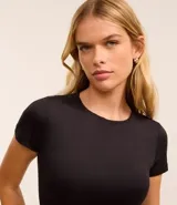 Body de cuello redondo y manga corta, confeccionado en tejido de poliamida con elastano. Presenta un diseño liso y ajustado al cuerpo con cierre en la entrepierna.