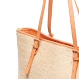 Cartera tote de diseño estructurado, confeccionada con tejido efecto rafia en color beige y detalles en cuerina tostada. Cuenta con asas largas de hombro y tiras decorativas frontales con hebillas.