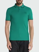 Remera polo de algodón, color verde, de corte slim fit, con cuello y puños ribeteados en negro y tres botones frontales.