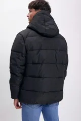 Campera puffer negra con diseño capitoneado, cierre frontal completo y capucha integrada.