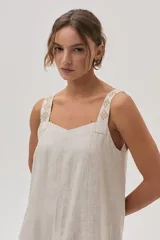 Vestido largo color beige de lino con tiras bordadas.