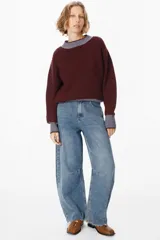 Sweater de punto grueso con diseño bicolor, cuerpo en color crema y detalles en color beige en cuello, puños y ruedo. Presenta mangas largas con caída relajada y cuello redondo.