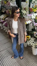 Blazer de corte sastrero con estampado de cuadros en tonos marrones y beige, con solapas clásicas, cierre frontal de dos botones y mangas largas con forro interno en contraste.