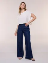 Jean de tiro alto y pierna amplia de corte wide leg, confeccionado en denim azul. Presenta cintura plana en el frente y elastizada en la espalda, bolsillos delanteros aplicados estilo parche y pespuntes a contrapunto.