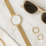 Reloj analógico Mini Focus con caja redonda de metal dorado y malla de acero tipo milanesa. Esfera blanca minimalista con indicadores de hora en puntos dorados y movimiento de cuarzo japonés.