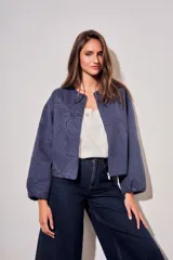 Campera bomber de algodón color azul, con diseño de bordado floral en tono sobre tono, cierre frontal y mangas largas con puños elásticos.