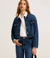 Campera de jean azul oscuro, corte cropped, con cuello camisero, abotonadura frontal y bolsillos tipo western.