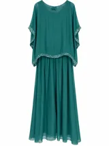 Vestido largo verde esmeralda con diseño de doble capa, escote redondo con detalle de lazo en la espalda y mangas murciélago con detalles de pedrería y lentejuelas en los bordes.