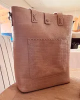 Bolso matero color beige con textura croco, con correa larga regulable y bolsillo exterior para lentes.