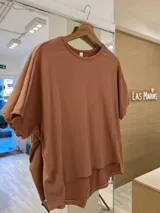 Remerón blanco de morley de algodón, manga corta, con dos pequeñas aberturas frontales y terminación en pico en la parte trasera.