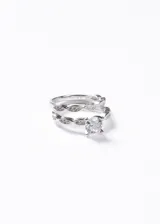 Set de dos anillos de plata 925 con diseño entrelazado tipo infinito, decorados con zirconias engastadas. El anillo principal presenta una zirconia central de corte redondo.