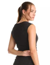 Vestido corto sin mangas con cuello volcado y detalle de drapeado horizontal en la cintura. Confeccionado en tejido con acabado brillante tipo lurex, presenta un corte ajustado que estiliza la figura.