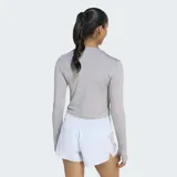 Remera de running manga larga Adidas, de corte ajustado y diseño cropped. Presenta cuello redondo, aberturas para los pulgares en los puños y logo de la marca reflectante en el pecho. Confeccionada con tecnología Climacool para la gestión de la humedad.