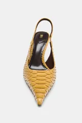 Zapato de tacón alto fino con diseño destalonado, acabado en punta y textura con relieve tipo piel de serpiente en color mostaza.