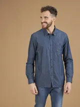Camisa de manga larga azul con pequeños lunares blancos, cuello clásico y bolsillo en el pecho.