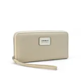Billetera larga con cierre perimetral, confeccionada en material sintético texturizado color mostaza. Cuenta con correa de mano extraíble y placa metálica con logo de la marca en el frente.