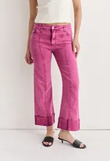 Pantalón de jean de tiro alto, color fucsia con efecto acid wash/teñido. Corte acampanado (flare) con costuras marcadas en el frente y dobladillos anchos y fijos en el ruedo.