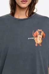 Remera de corte oversize color gris oscuro con efecto lavado, cuello redondo y manga corta amplia. Presenta un estampado pequeño de un perro salchicha con el logo de la marca en el pecho.